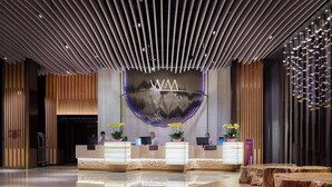 Un área de recepción moderna con un mostrador central, detalles de madera y un diseño de techo único.