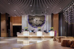 Un área de recepción moderna con un mostrador central, detalles de madera y un diseño de techo único.