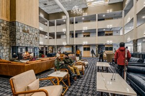 A spacious lobby with a stone fireplace, leather seating, and a high ceiling with exposed beams. - Beautiful Views New Deck Wi-Fi (Snowshoe)