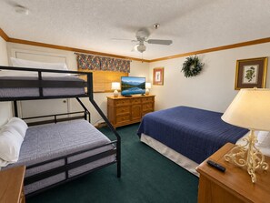 A room with bunk beds, a television, a dresser, a lamp, and a framed picture on the wall. - Beautiful Views New Deck Wi-Fi (Snowshoe)