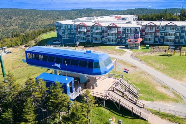 A large, multi-story building with a prominent blue bus-shaped structure in front. - Beautiful Views New Deck Wi-Fi (Snowshoe)