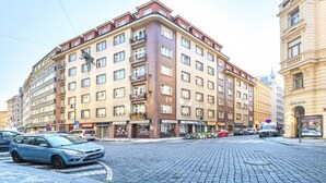 A multi-story hotel with a corner entrance, multiple balconies, and a variety of ground-level shops. - Stylish Apartment in Prague 1 Close to Old Town Square by EasyBNB Premium (Prague)