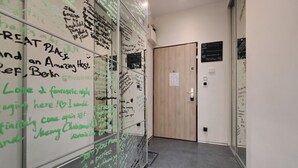 A hallway with glass walls covered in handwritten messages and a wooden door. - Stylish Apartment in Prague 1 Close to Old Town Square by EasyBNB Premium (Prague)