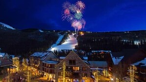 A snow-covered mountain town at night with illuminated buildings and a fireworks display. - 31GlenEagle Cozy Townhome | 2 Bedroom 2 Bathroom, GlenEagle Townhome Whistler, Golf/Ski community (Whistler)