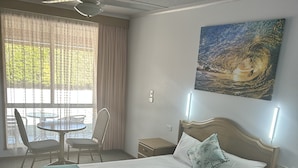 A hotel room with a bed, bedside tables, a desk, and a chair.
