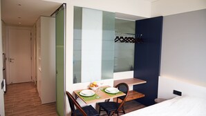 A hotel room with a dining area, a bed, and a wardrobe. - Studio - Serviced Apartment Sea View - Isla Melocotón Ven67 Phu Quoc (Thành phố Phú Quốc)