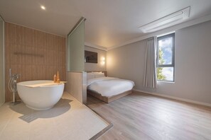 A modern bedroom with a large bathtub, a bed, and a window with curtains. - Anook Thepeak Hotel Incheon Songdo (Incheon)