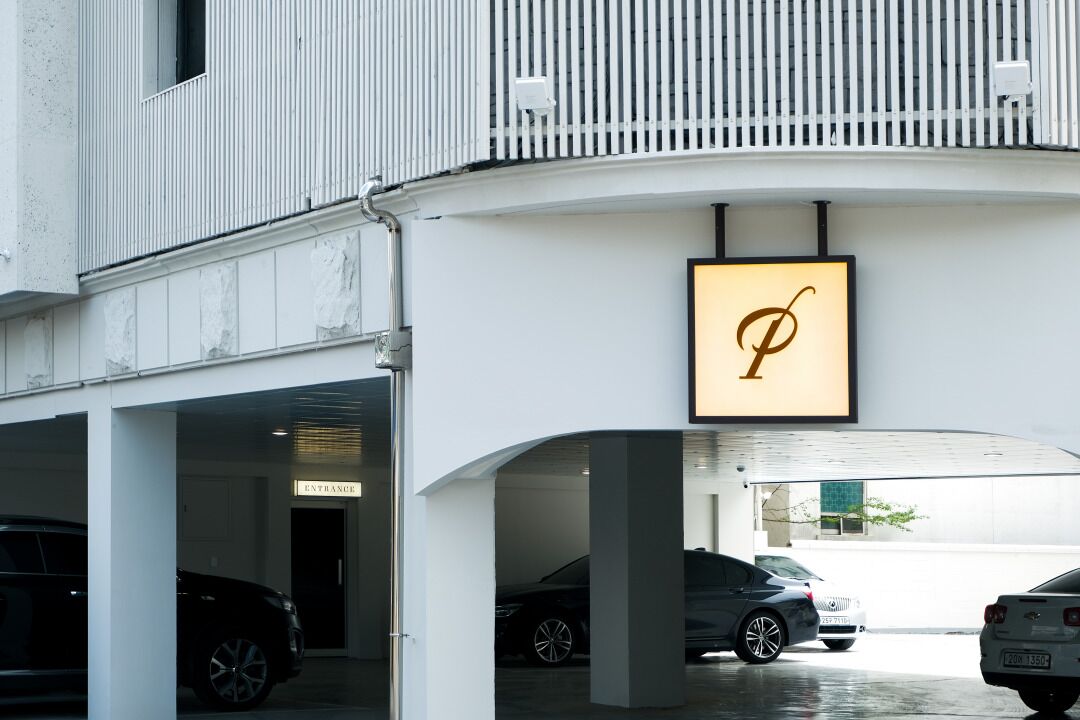 A modern building with a parking garage entrance labeled "ENTRANCE."