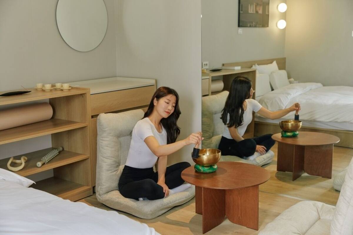 A hotel room with a bed, a sitting area with a table, and a mirror.