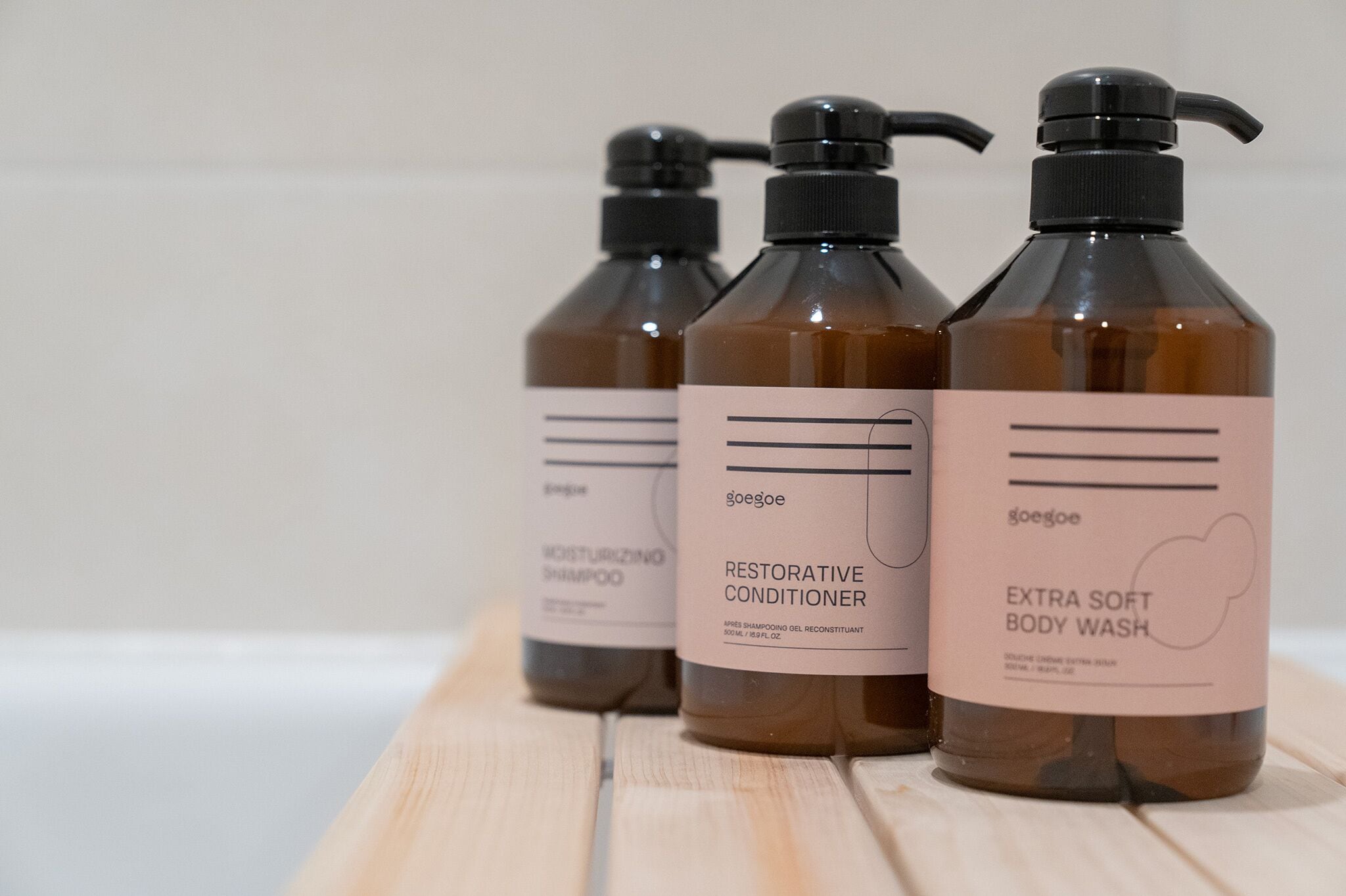 Three bottles of body wash on a wooden surface.