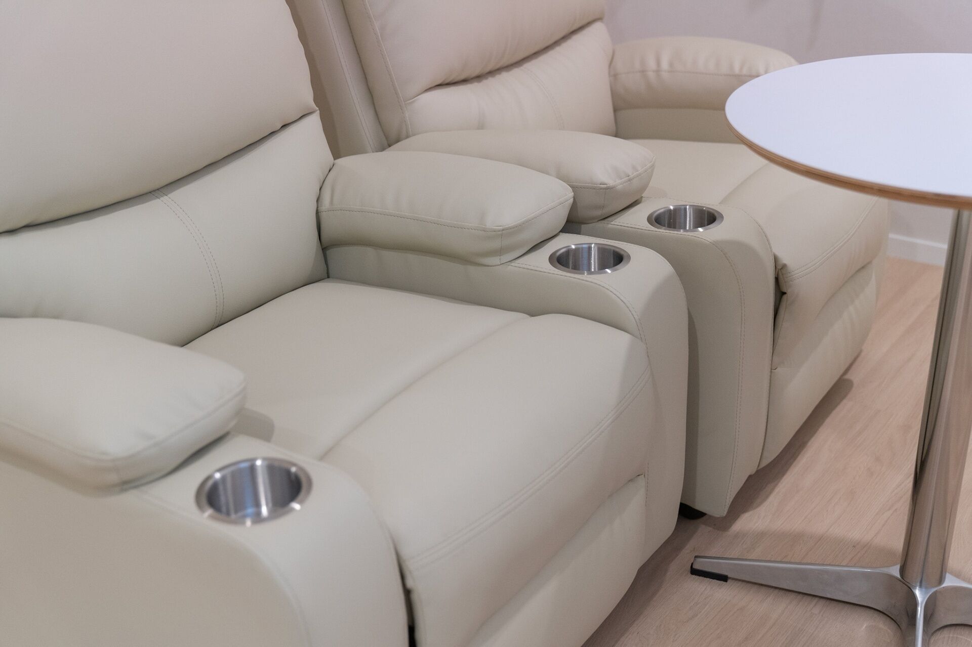 Un canapé modulable avec des porte-gobelets et une petite table.