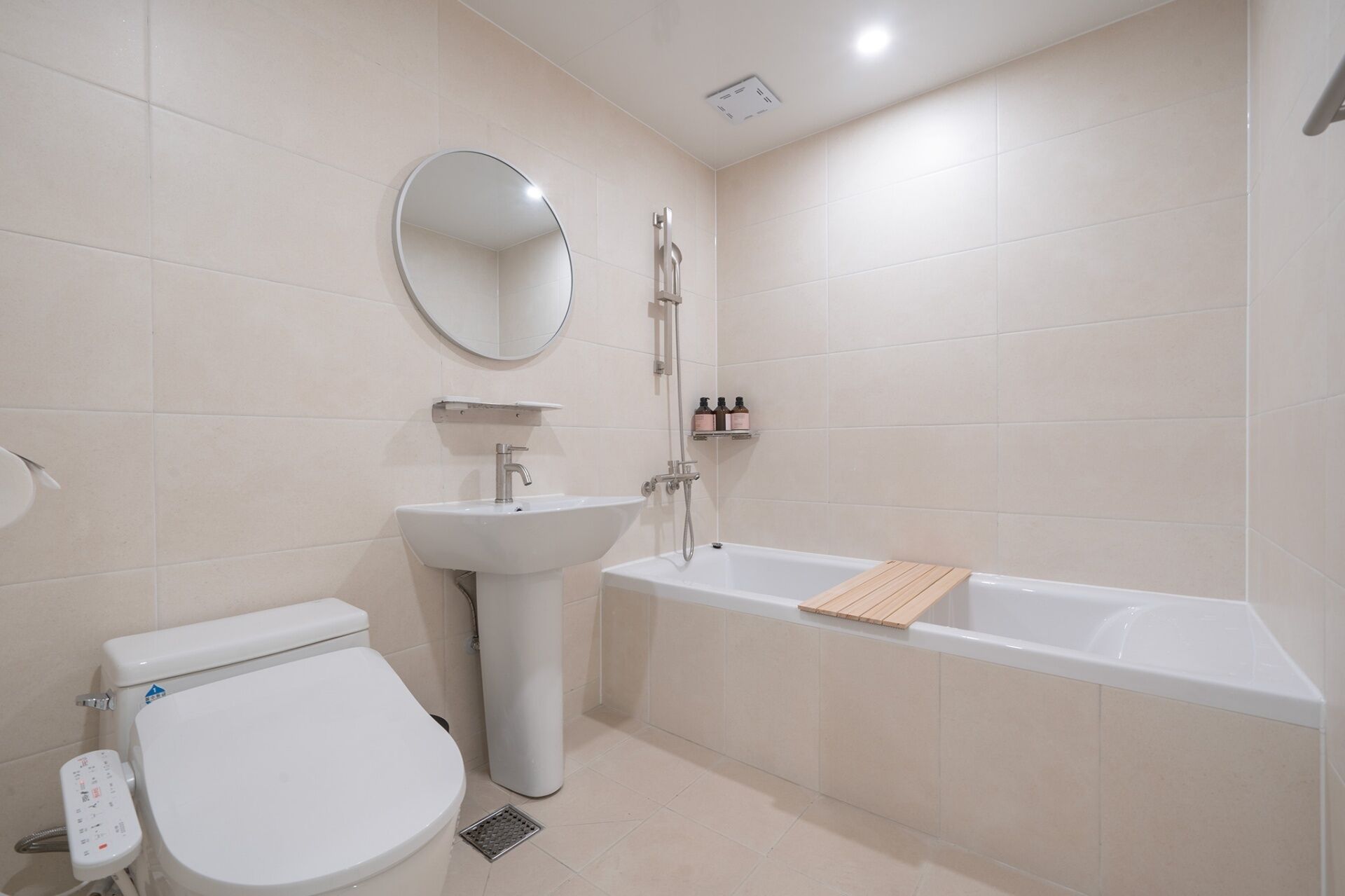 A modern bathroom with a toilet, sink, and bathtub.
