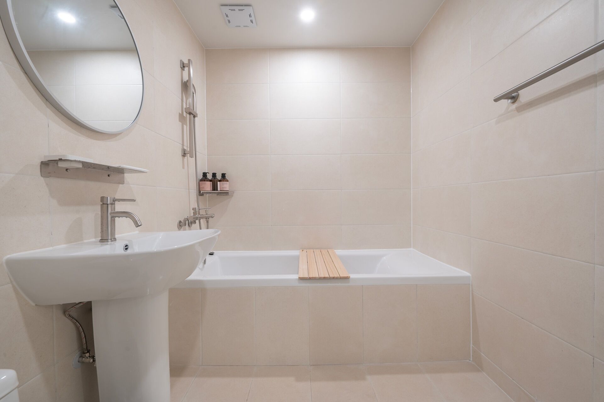 A modern bathroom with a white sink, a bathtub, and a shower.