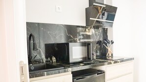 Una cocina con microondas negro, fregadero y lavavajillas.