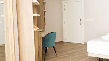 Un dormitorio con cama, escritorio y silla.