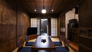 A traditional Japanese-style room with tatami flooring, a low wooden table, and sliding doors. - Rinn Shijo Machiya (Kyoto)