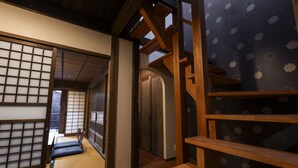 A traditional Japanese interior with tatami flooring, sliding doors, and wooden beams. - Rinn Shijo Machiya (Kyoto)