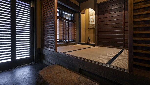 A traditional Japanese room with tatami flooring, sliding doors, and a wooden bench. - Rinn Shijo Machiya (Kyoto)