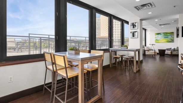 A modern interior with a dining area, large windows, and a view of the cityscape.