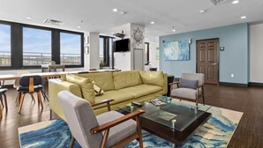 A modern living room with a sofa, armchairs, a coffee table, and a TV.