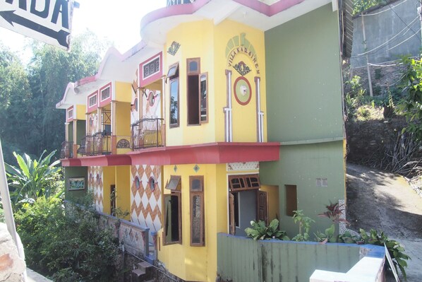 A multi-story building with balconies and a sign reading "Villa Karoline". - OYO Life 90646 Villa Karsinem Pasuruan (Prigen)