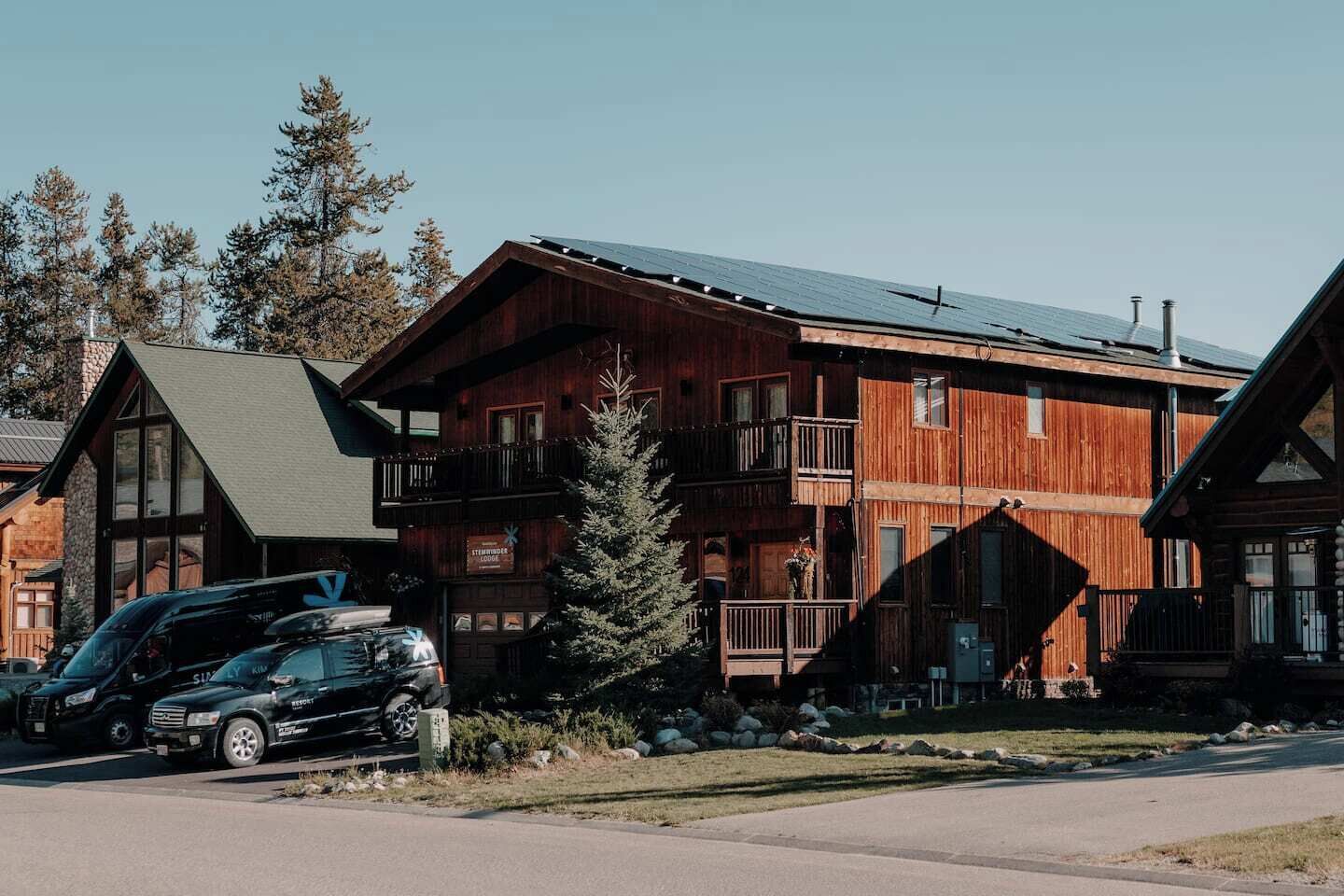 A multi-story wooden lodge with balconies and a ski lift visible in the background.