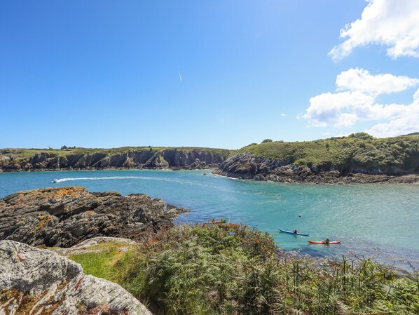 Un paysage côtier caractérisé par des rivages rocheux, une eau d’un bleu limpide et une végétation luxuriante.