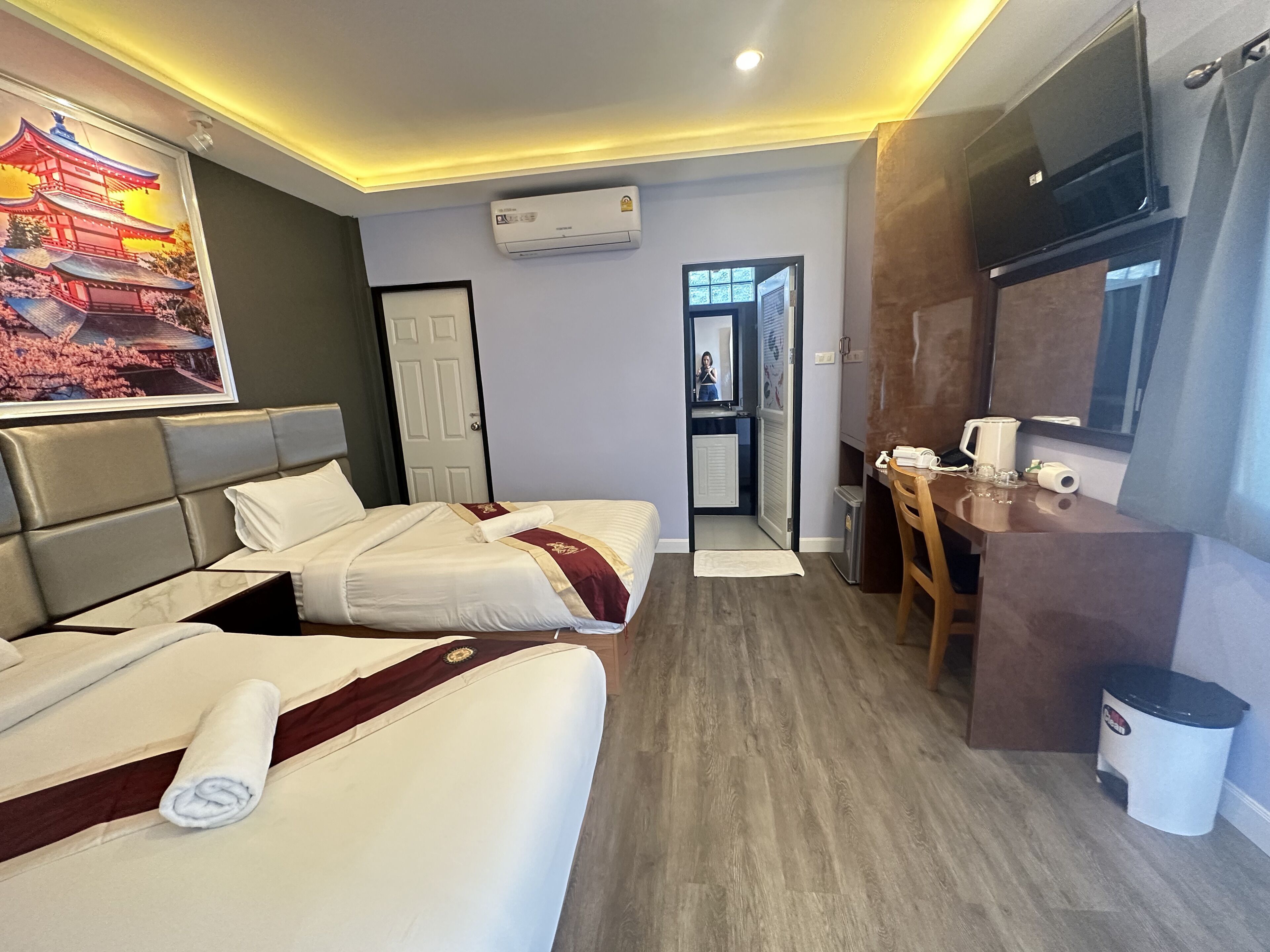 Une chambre d’hôtel équipée d’un lit, d’un bureau, d’une télévision et d’un appareil de climatisation.