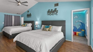 Un dormitorio con dos camas, ventilador de techo y un mural en la pared.