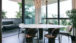 A modern dining area with a round table, six chairs, and a unique chandelier. - Luxury Suite in bosco Verticale Milano Isola  (Milano)
