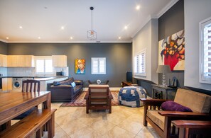 Een moderne woonkamer met een houten eettafel, een bank, een relax fauteuil en een televisie.