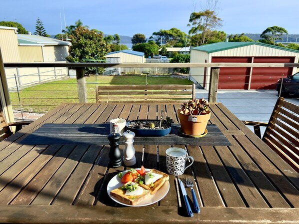 A wooden table with a plate of toast, a cup, and utensils.
