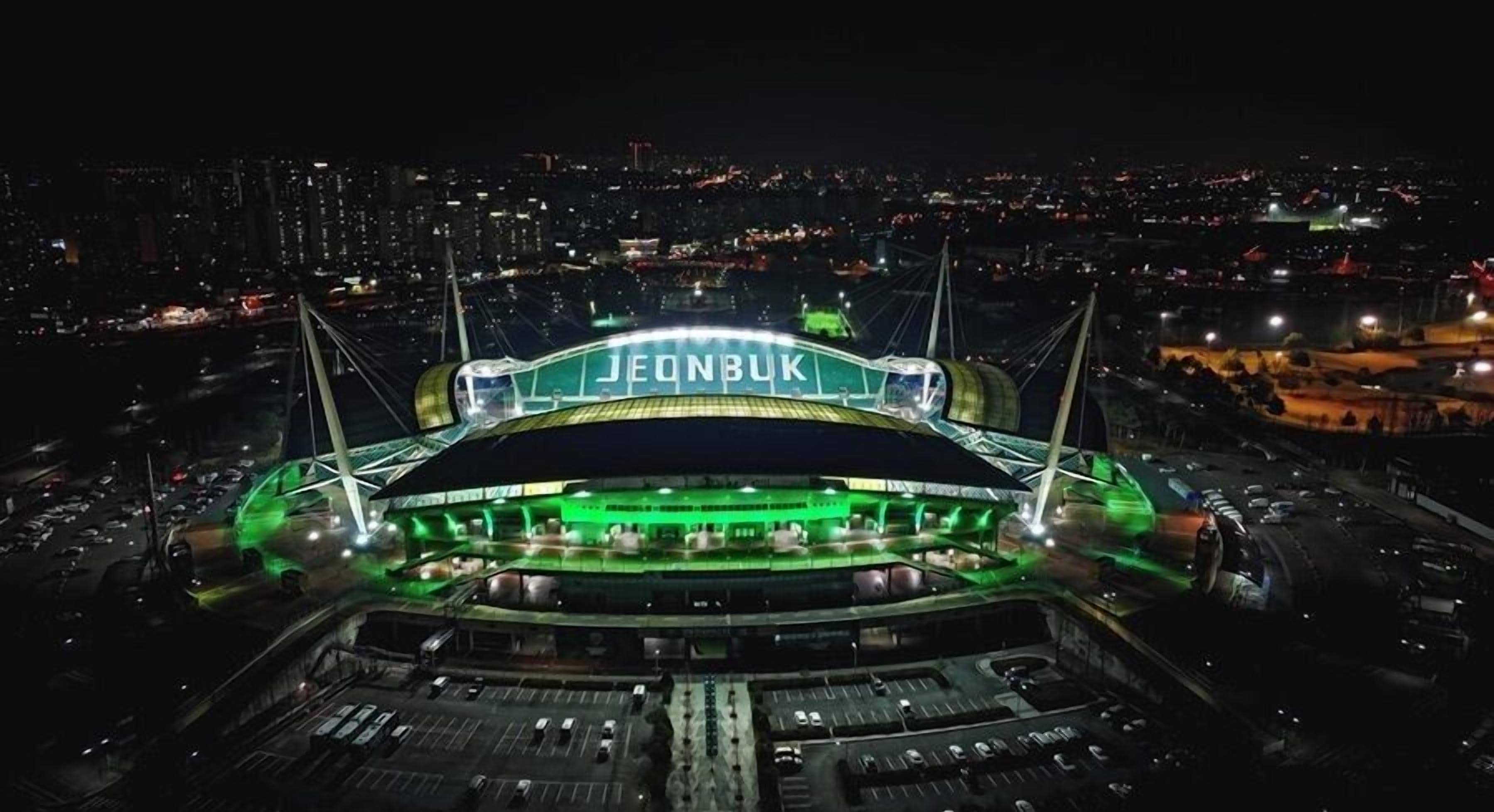A stadium with a large, illuminated sign reading "JEONBUK".