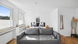 A modern living room with a grey sofa, a small wooden table, and a radiator.
