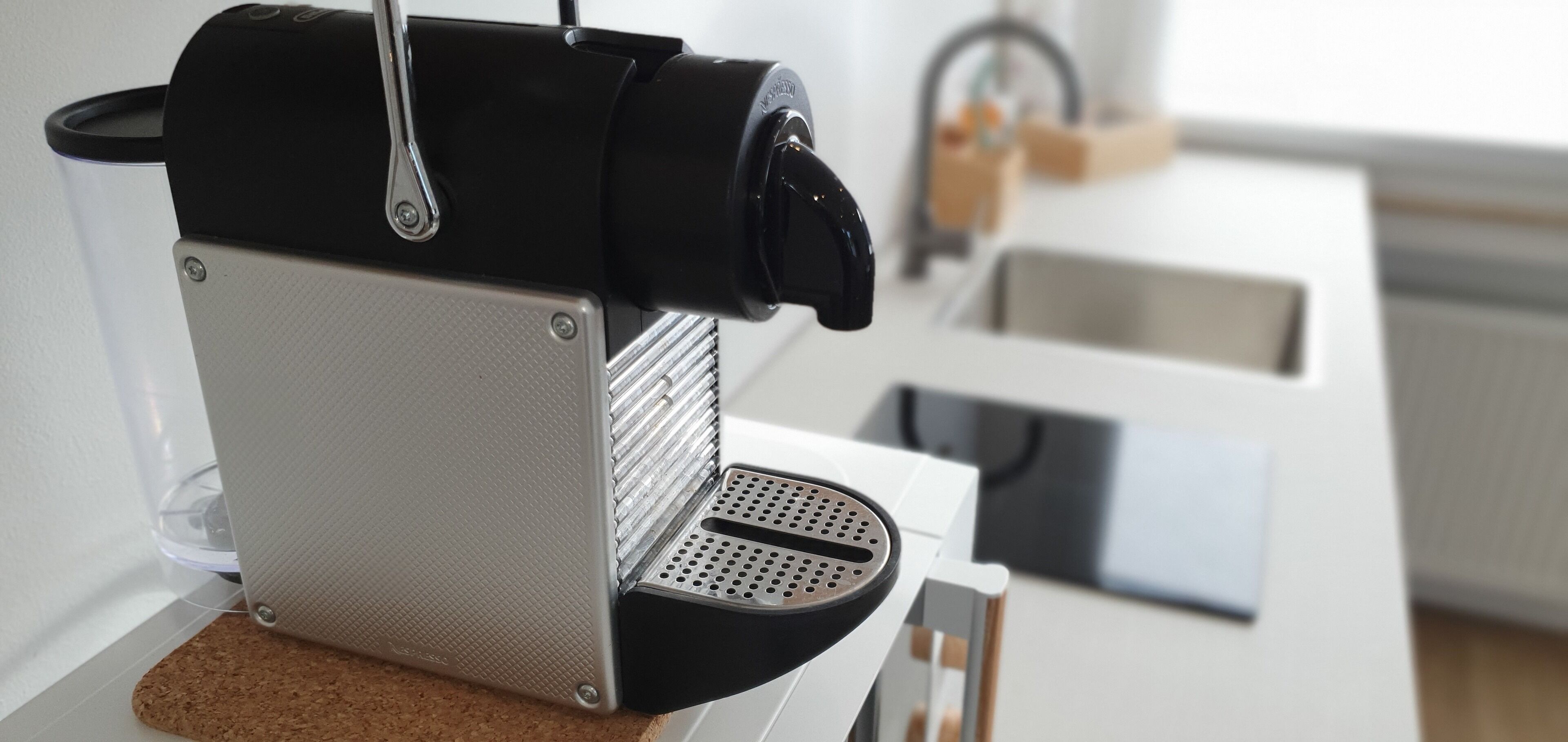 A kitchen with a coffee machine, a sink, and a countertop.