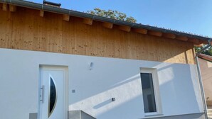 A building with a wooden facade, a white exterior, and a small window. - holiday flat "Felina" (Passau)