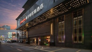 Een modern hotelgebouw met verlichte reclameborden en grote ramen.
