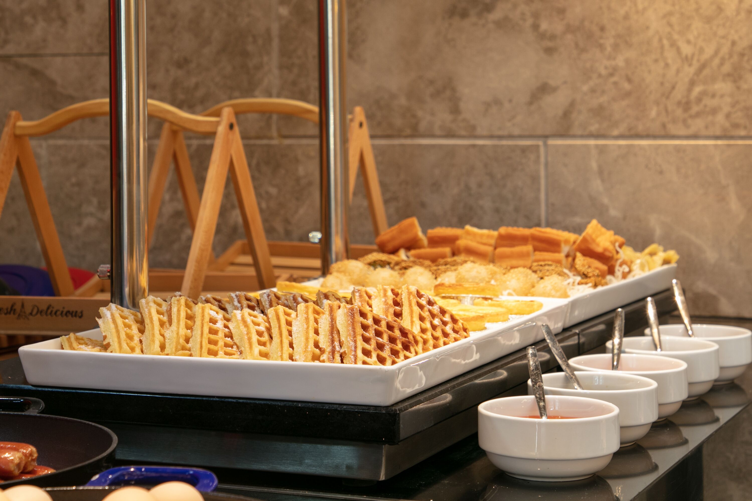Een buffet met wafels en verschillende sauzen.