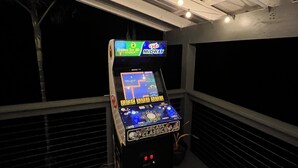Une salle d’arcade proposant de nombreux jeux sur différents écrans, notamment « Golden Tee 3D Golf » et « Midway ».