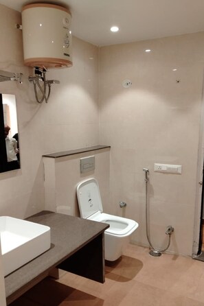 A modern bathroom with a toilet, bidet, and shower. - Hotel Park Regency (Gorakhpur)