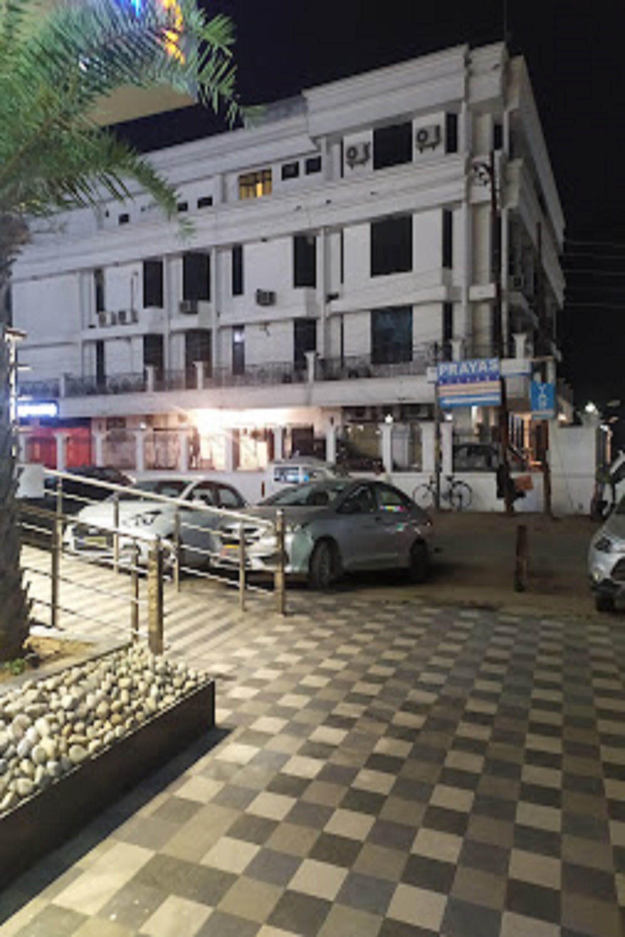 A multi-story building with a checkered pavement in front.