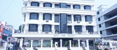 Un edificio de varios pisos con un letrero que dice "HOTEL PARK REGENCY".