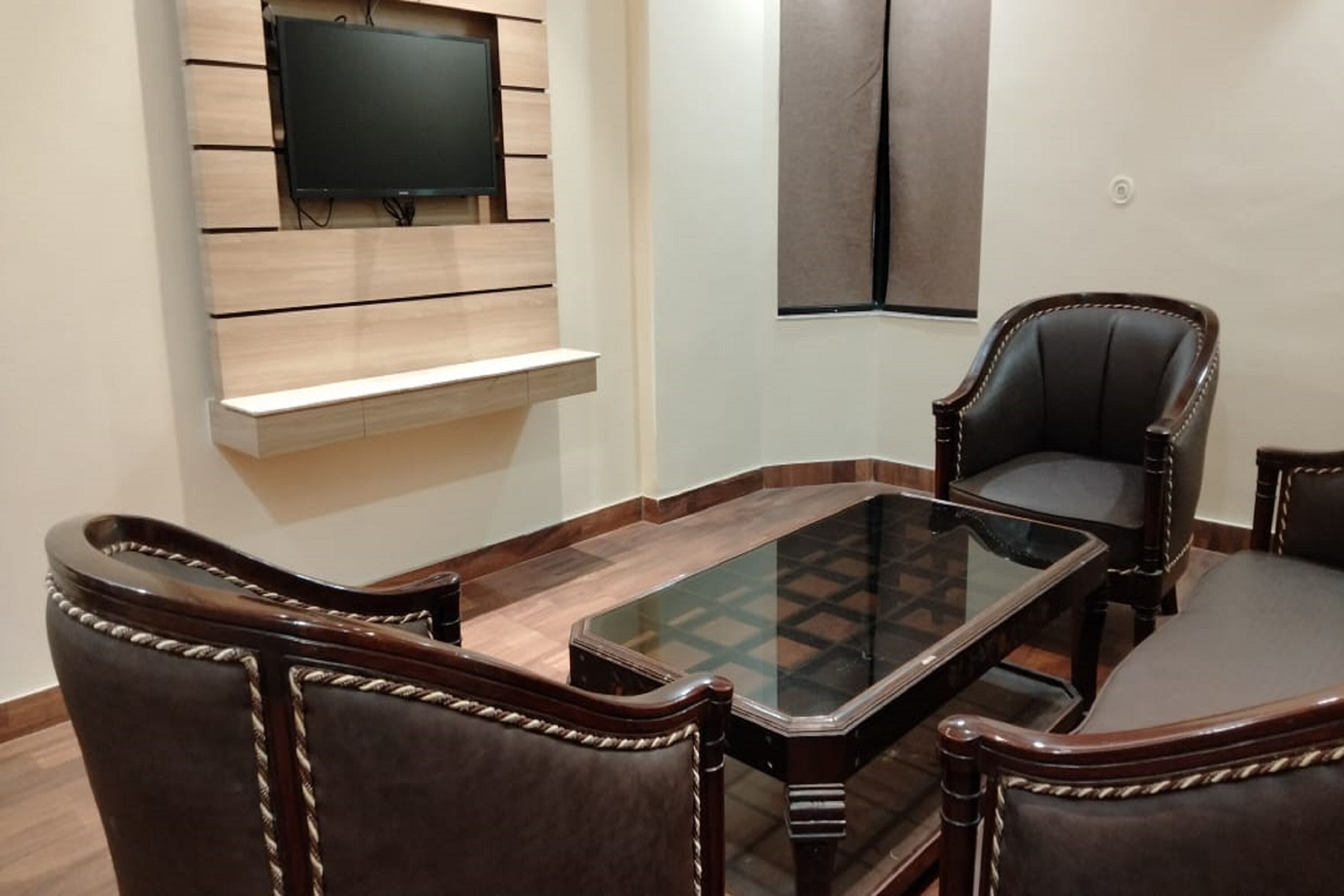Un área de comedor con una mesa de vidrio y cuatro sillas tapizadas de estructura de madera y detalles de cuerda.