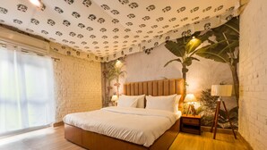 A bedroom with a wooden bed, a brick wall, and a ceiling with a palm tree pattern. - Vanbagh Sariska Resort (Alwar)