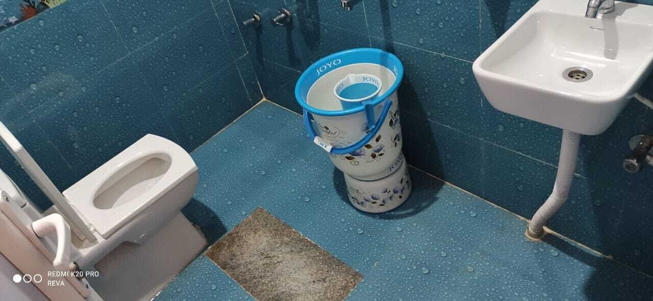 A bathroom with a toilet, a sink, and a toilet paper holder.