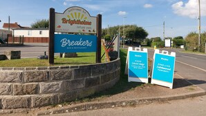 A sign for 'Brightholme Holiday Park' and 'Breakers Bar & Restaurant' with a contact number. - 2 Brightholme 6 Berth With Decking & Enclosed Gard (Burnham-on-Sea)