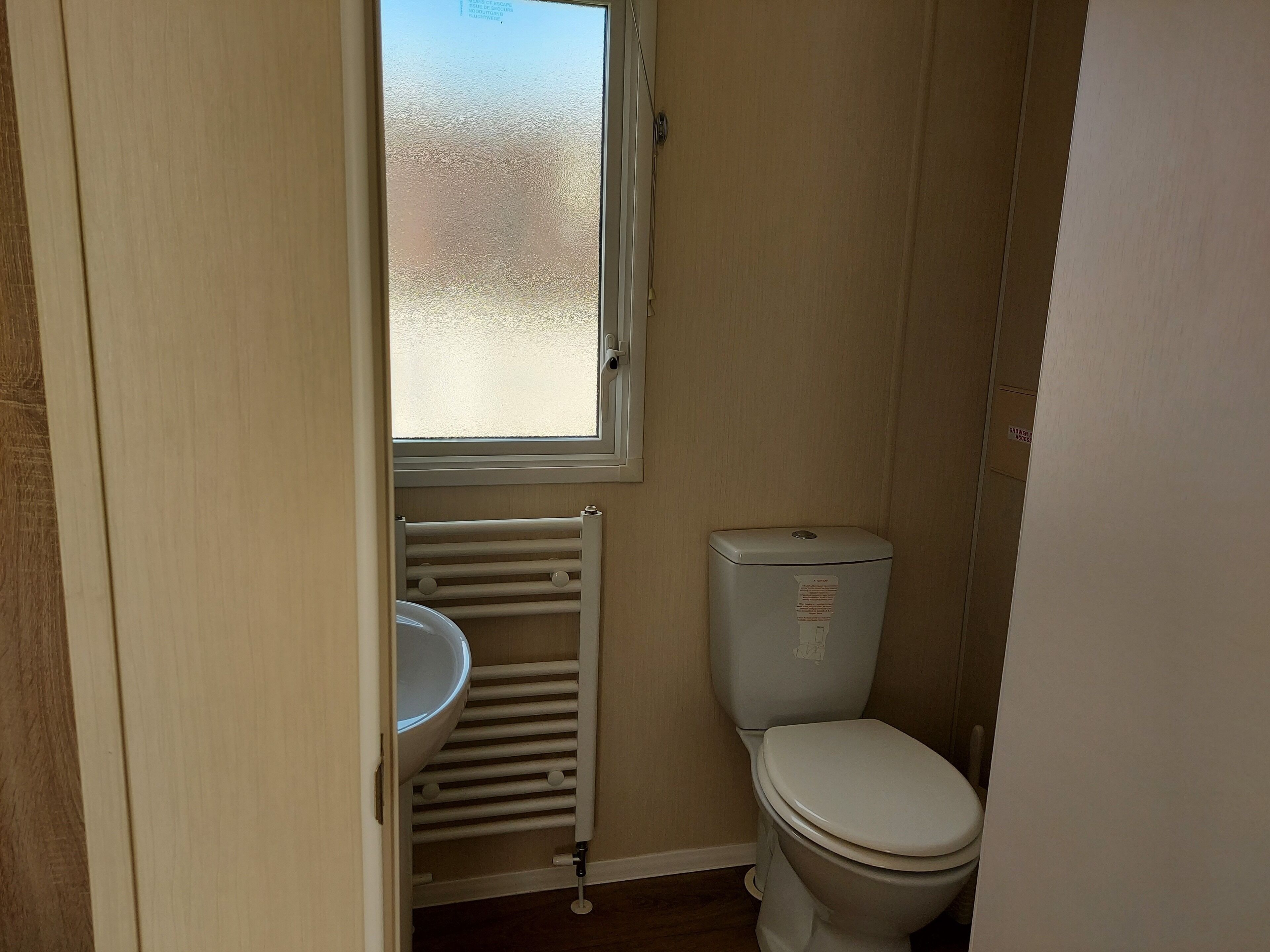 Un bagno piccolo e compatto con il water, un lavandino e un termosifone.