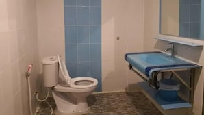 A bathroom with a toilet, sink, and mirror. - Ruen Bua resident (Warin Chamrap)