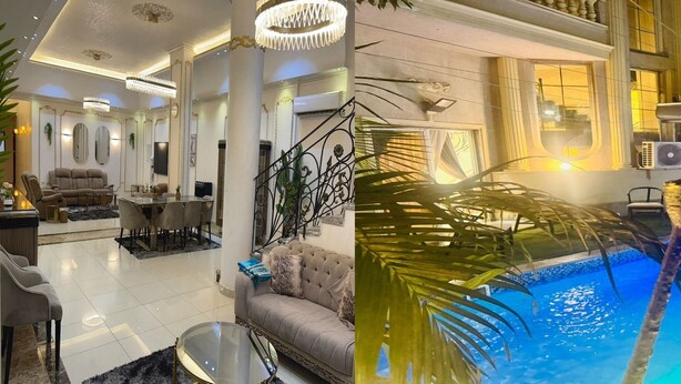 Een luxe woonkamer met een eetgedeelte, een trap met decoratieve balustrades en een zwembadgedeelte met palmbomen.