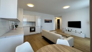 Een modern appartement met keuken, eethoek en woonkamer.